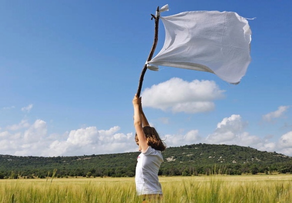 girl-holding-high-a-white-flag-in-wheat-field